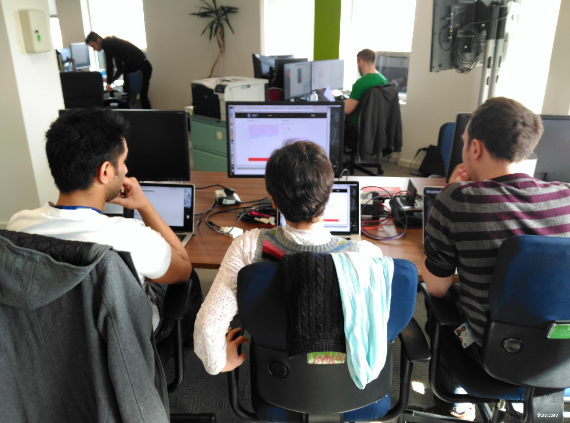 Photograph of a service team looking at a screen