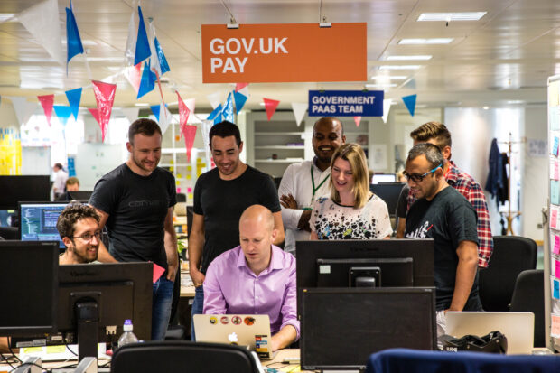 Photo of the GOV.UK Pay team gathered at a computer screen to watch Till Wirth make the first credit card payment using the GOV.UK Pay product.